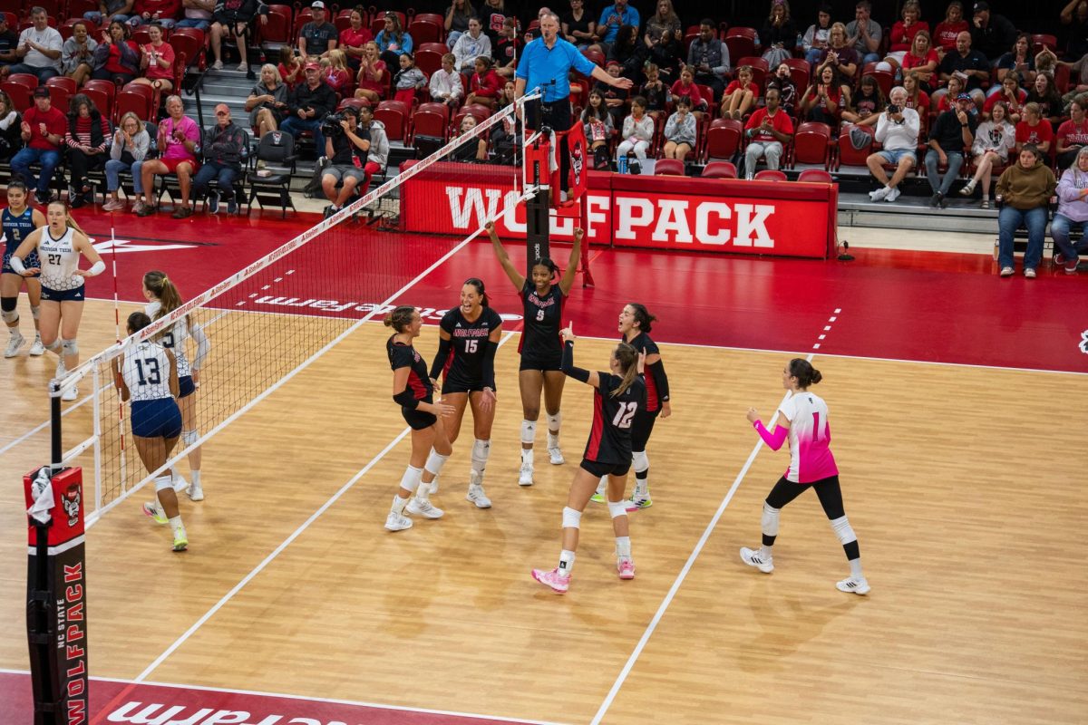 NC State women’s volleyball team celebrates with the crowd after scoring a point during the game against Georgia Tech in Reynolds Coliseum on Sunday, Oct. 19, 2025. NC State lost to Georgia Tech 0-3.