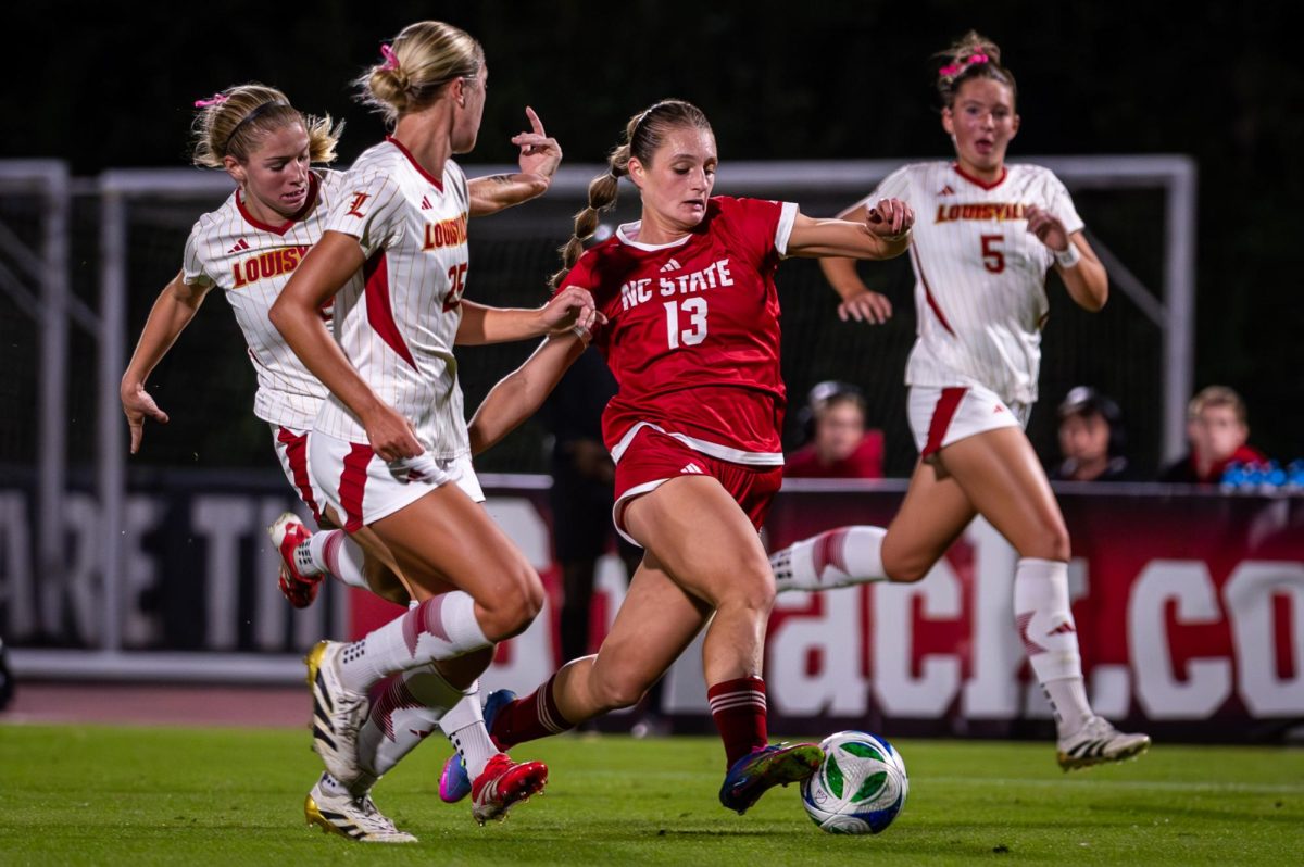 Junior forward Jade Bordeleau dribbles the ball around defenders during the game against Louisville at Dail Soccer Stadium on Thursday, Oct. 23, 2025. The Cardinals defeated the Wolfpack 3-0.