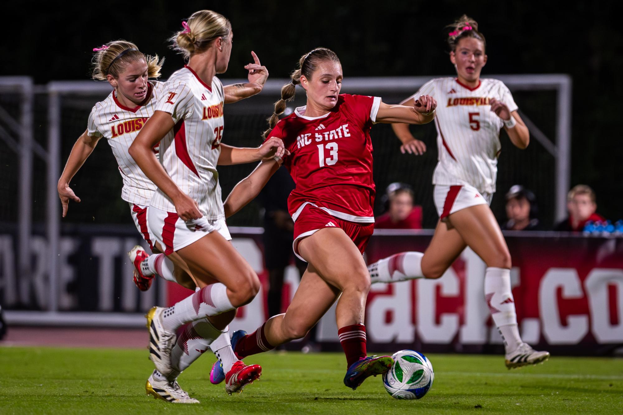 Junior forward Jade Bordeleau dribbles the ball around defenders during the game against Louisville at Dail Soccer Stadium on Thursday, Oct. 23, 2025. The Cardinals defeated the Wolfpack 3-0.