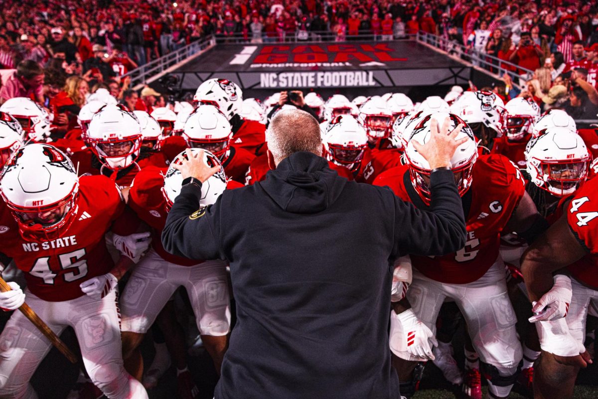NC State football head coach Dave Doeren sways with his team before running out on the field before the game against Florida State at Carter-Finley Stadium on Friday, Nov. 21, 2025. NC State beat Florida State 21-11.