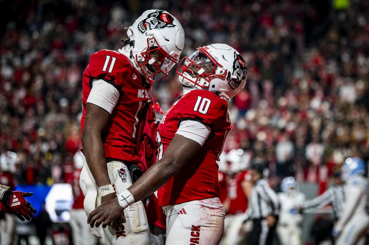 Sophomore quarterback CJ Bailey and freshman quarterback Will Wilson celebrate on the field after scoring a touchdown during the game against UNC in Carter-Finley Stadium on Saturday, Nov. 29, 2025. The Wolfpack defeated the Tar Heels 42-19.