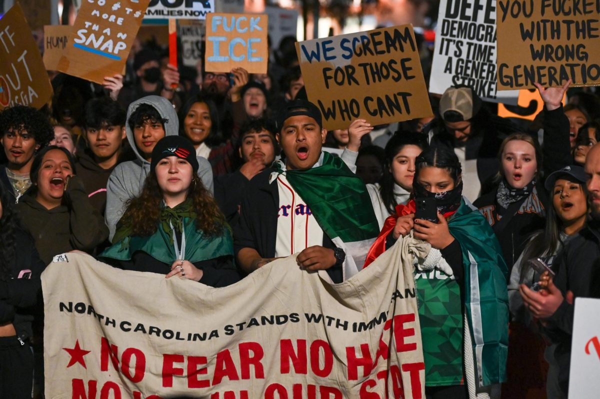 Protesters carry a banner and chant in Downtown Raleigh during the "No Border Patrol in Raleigh" protest on Tuesday, Nov. 18, 2025. Hundreds of members and organizations of the Research Triangle community gathered to protest the ICE raids.