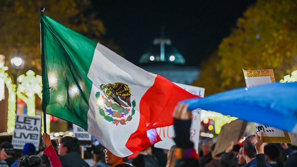 Flag of Mexico waving as protesters march towards the Capitol Building during the "No Border Patrol In Raleigh" protest in Downtown Raleigh on Tuesday, Nov. 18, 2025. Hundreds of members and organizations of the Research Triangle community gathered to protest the ICE raids.