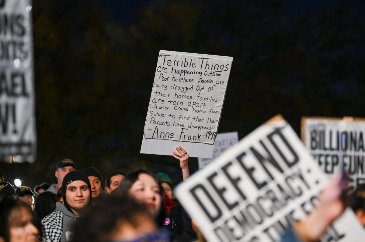 A Poster containing a quote from Anne Frank is raised in downtown Raleigh during the "No Border Patrol in Raleigh" protest on Tuesday, Nov. 18, 2025. Hundreds of members and organizations of the Research Triangle community gathered to protest the ICE raids.