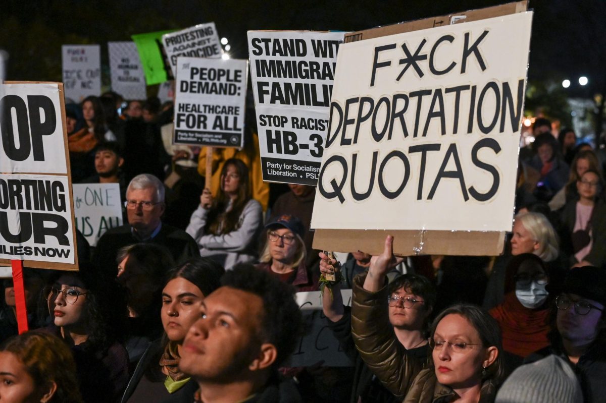 Protesters raise posters and chant during the "No Border Patrol" protest in Downtown Raleigh on Tuesday, Nov. 18, 2025. Hundreds of members and organizations of the Research Triangle community gathered to protest Immigration and Customs Enforcement raids.