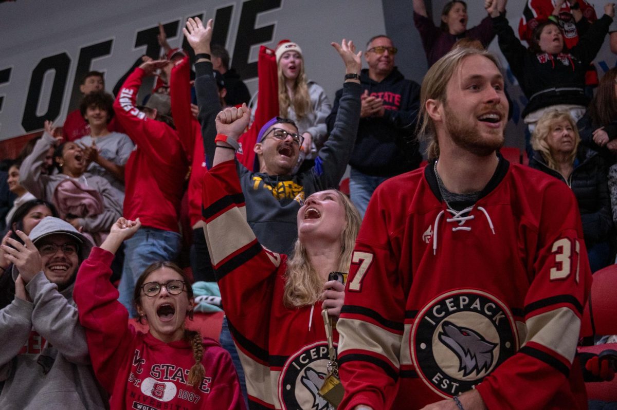 Icepack fans cheer in triumph as the final overtime goal is scored during the game at Invisalign Arena on Friday, Nov. 14,  2025. NC State defeated Alabama 4-3.