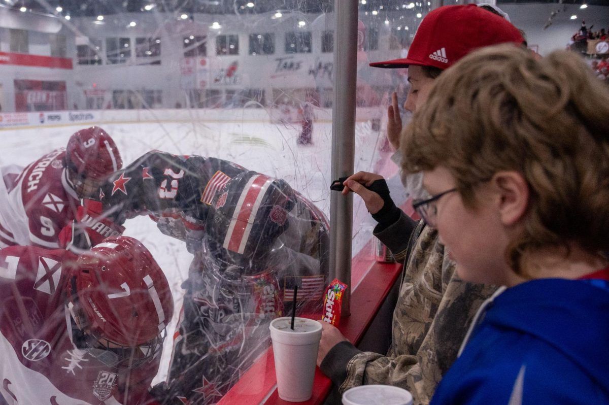 Fans watch as senior defenseman Nicholas Librizzi battles for possession against the wall during the game at Invisalign Arena on Friday, Nov. 14,  2025. NC State defeated Alabama 4-3.