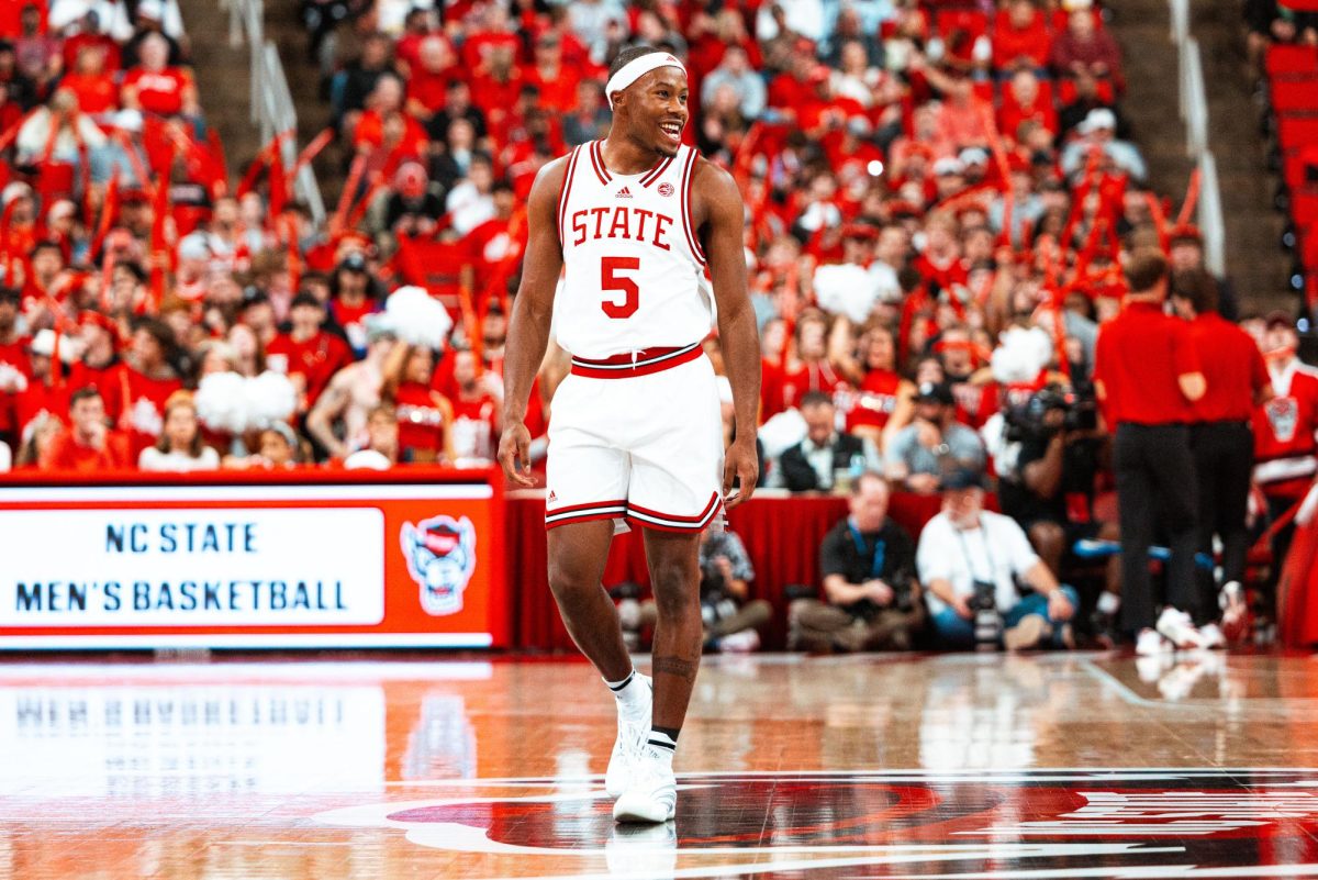 Senior guard Tre Holloman smiles while walking down the court during the game against NC Central at Lenovo Center on Monday, Nov. 3, 2025. Holloman scored 15 points. NC State beat NC Central 114-66.