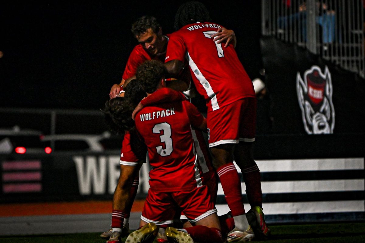 The teams gathers in a hug after their first goal during the game against Louisville at Dail Soccer Stadium on Wednesday, Nov. 24, 2025. The Wolfpack defeated the Cardinals 3-0.
