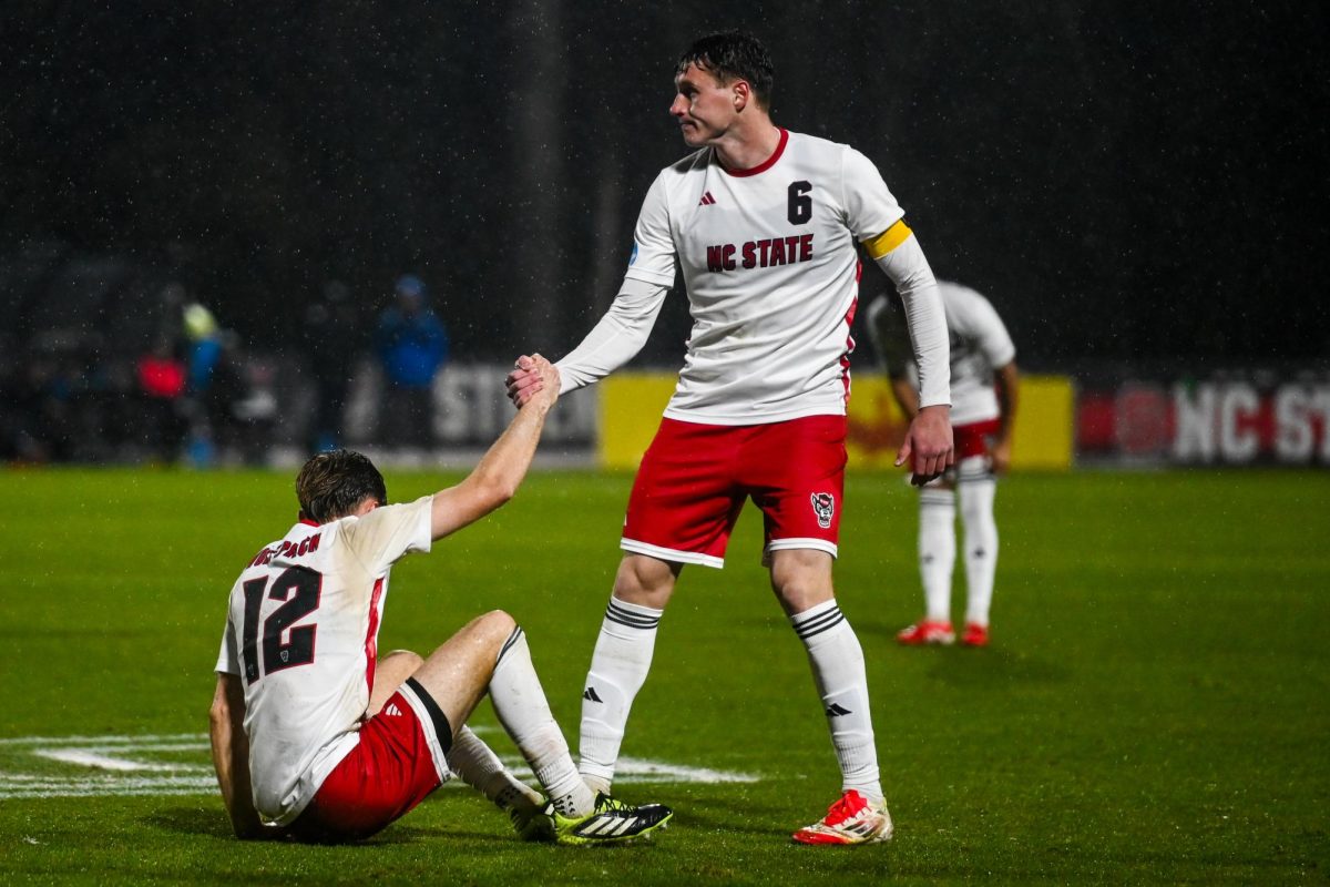 Sophomore defender Nikola Markovic helps up junior midfielder Tyler Caton during the game against UNCG in Dail Soccer Field on Sunday, Nov. 30, 2025. The Wolfpack defeated the Spartans 2-0.