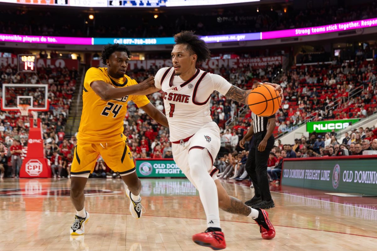 NC State senior forward Darrion Williams drives past a UNC Greensboro player during the game at the Lenovo Center on Wednesday, Nov. 12, 2025. Williams scored 32 points and had five assists. NC State beat UNC Greensboro 110-64.