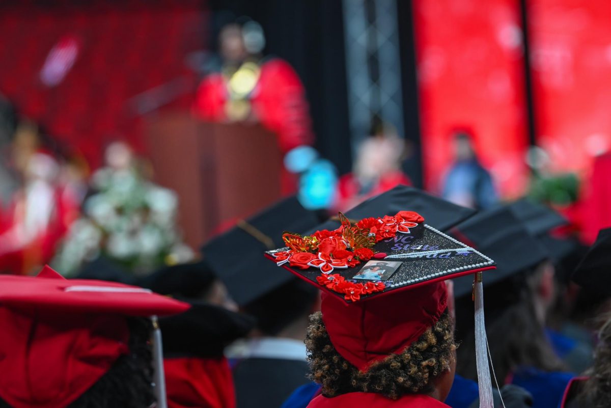 A student with a decorated cap sits during the Fall Commencement Ceremony in the Lenovo Center on Saturday, Dec. 13, 2025. The Fall Commencement honors both summer and fall 2025 graduates.