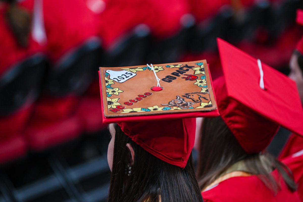 A student with a decorated cap sits during the Fall Commencement Ceremony in the Lenovo Center on Saturday, Dec. 13, 2025. The Fall Commencement honors both summer and fall 2025 graduates.