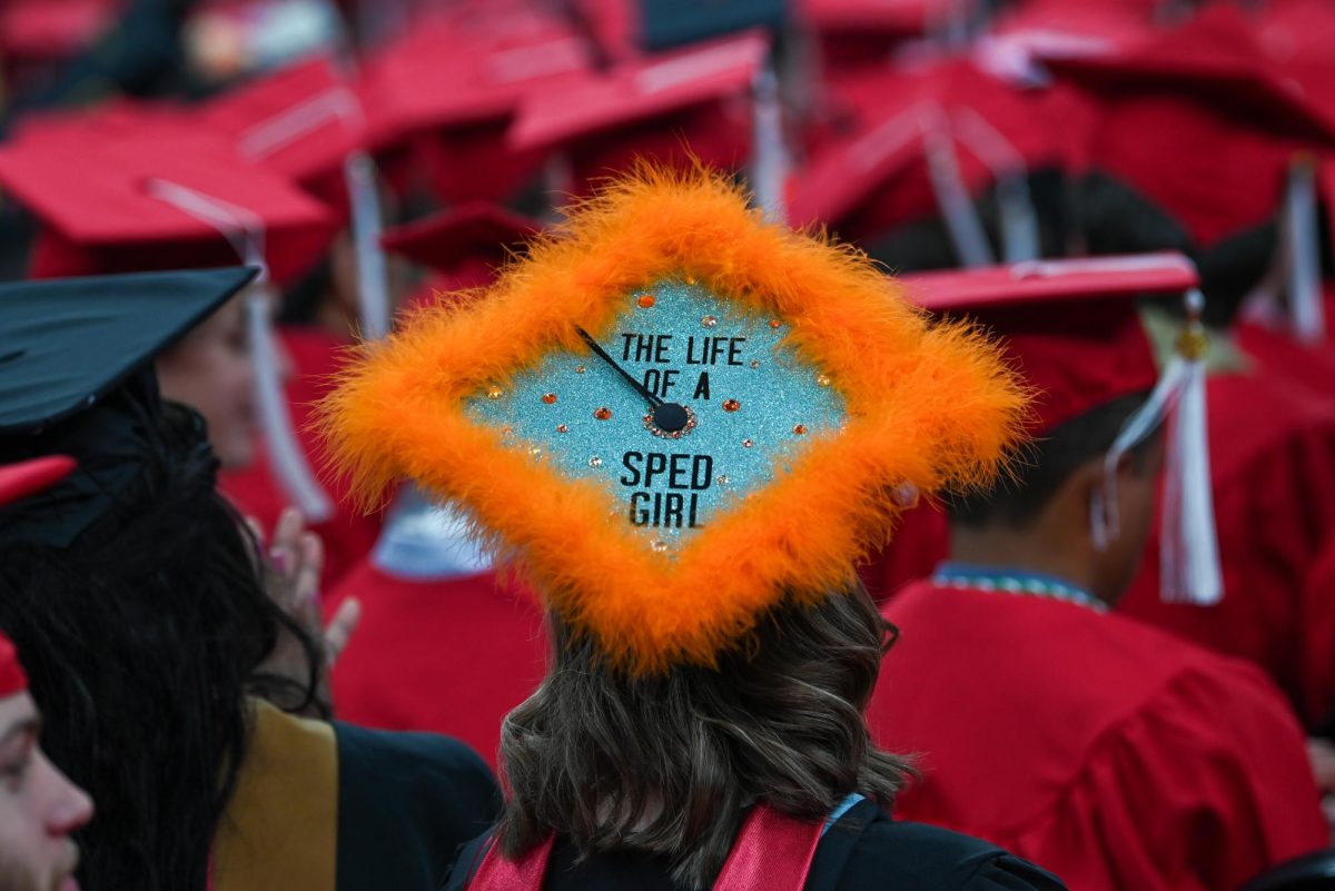 A student with a decorated cap sits during the Fall Commencement Ceremony in the Lenovo Center on Saturday, Dec. 13, 2025. The Fall Commencement honors both summer and fall 2025 graduates.