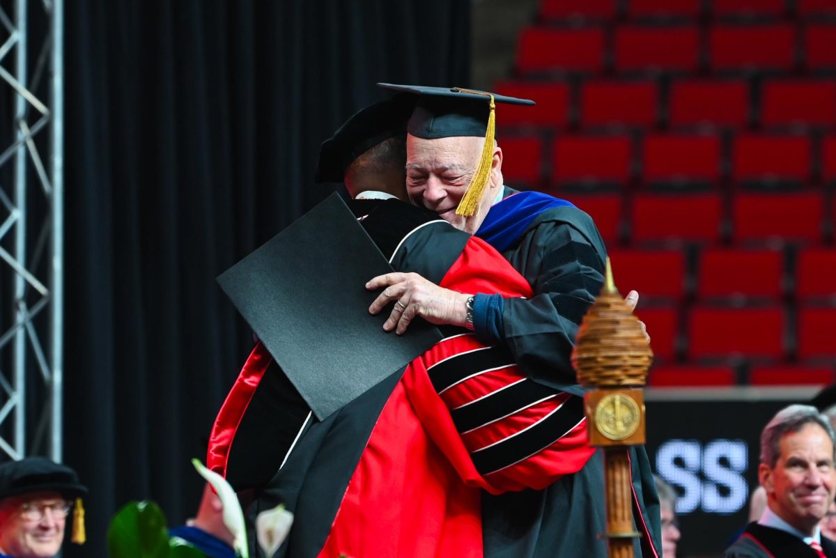 Kevin FitzGerald, a graduate receiving a doctor of design degree, happily hugs Chancellor Kevin Howell during the Fall Commencement Ceremony in the Lenovo Center on Saturday, Dec. 13, 2025. The Fall Commencement awarded 3,498 degrees to 3,384 graduates.