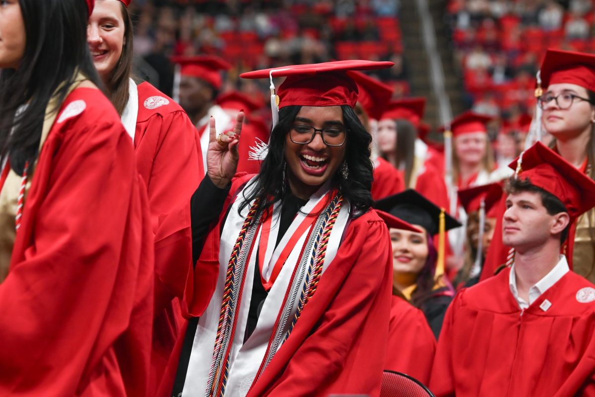 Joanna John, a fourth-year studying business administration, throws up a “wolfy” in celebration during the Fall Commencement Ceremony in the Lenovo Center on Saturday, Dec. 13, 2025. During the ceremony, graduates from all academic colleges including Engineering, Humanities and Social Sciences, Design and Agriculture and Life Sciences were recognized for their achievements