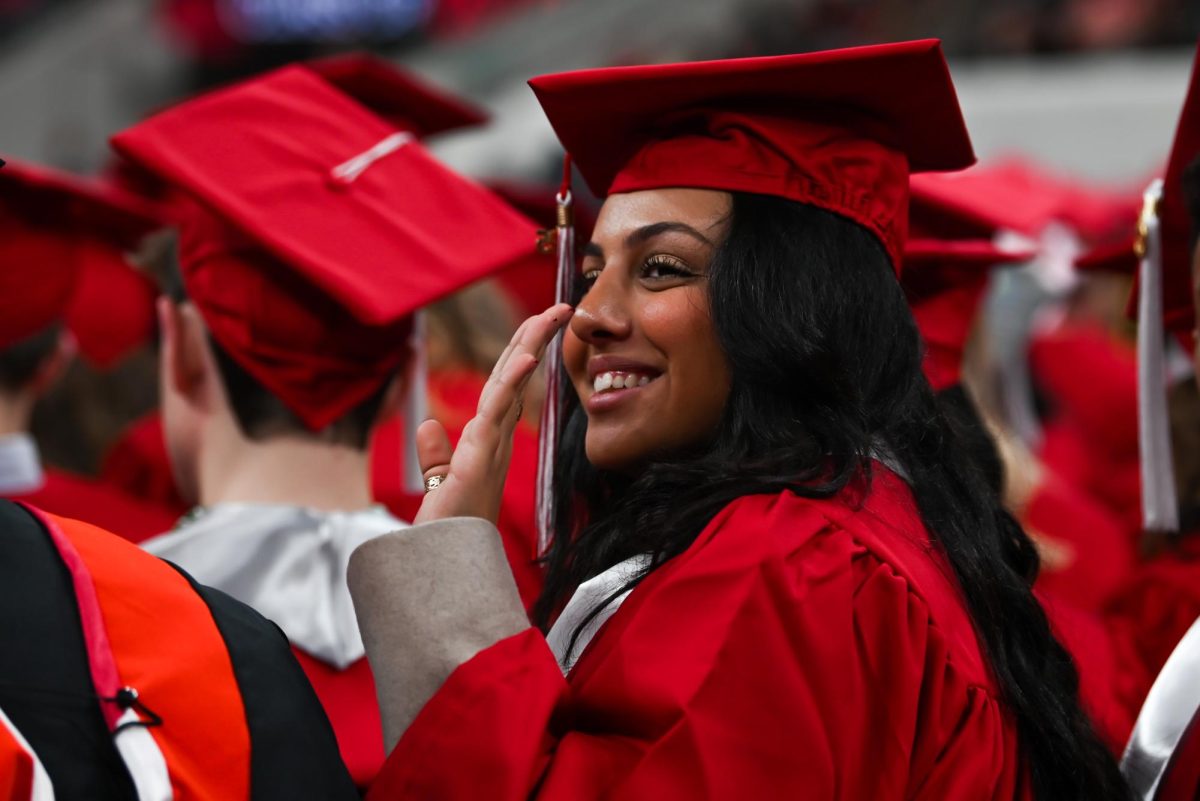 Joyce Rezk, a fourth-year studying psychology, waves to her friends and family in the audience during the Fall Commencement Ceremony in the Lenovo Center on Saturday, Dec. 13, 2025. During the ceremony, graduates from all academic colleges including Engineering, Humanities and Social Sciences, Design and Agriculture and Life Sciences were recognized for their achievements.