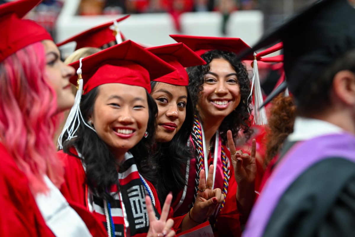 Sister of the Alpha Epsilon chapter of Kappa Phi Lambda Jenna Rose, a fourth-year studying bioprocessing science and sisters of the Epsilon Nu chapter of Lambda Theta Alpha Andrea Martinez, a fourth-year studying criminology, and Rebecca Hernandez, a fourth-year studying communications gesture to the camera during the Fall Commencement Ceremony in the Lenovo Center on Saturday, Dec. 13, 2025. The Fall Commencement awarded 3,498 degrees to 3,384 graduates.