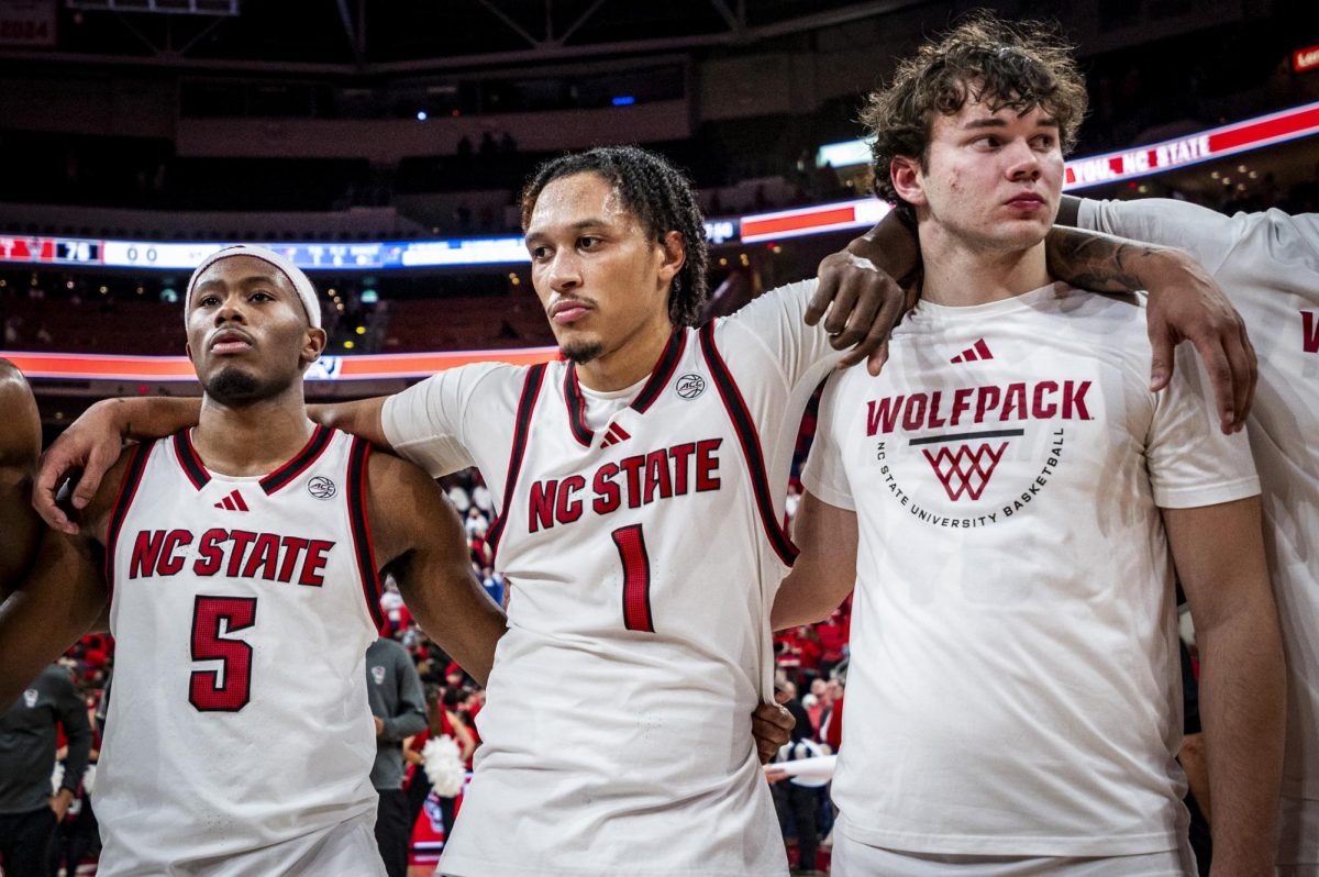 Senior guard Tre Holloman, senior forward Darrion Williams, and freshman forward Colt Langdon stand together after the game against Kansas in the Lenovo Center on Saturday, Dec. 13, 2025. Williams' buzzer-beating attempt came up short. The Jayhawks defeated the Wolfpack 77-76.