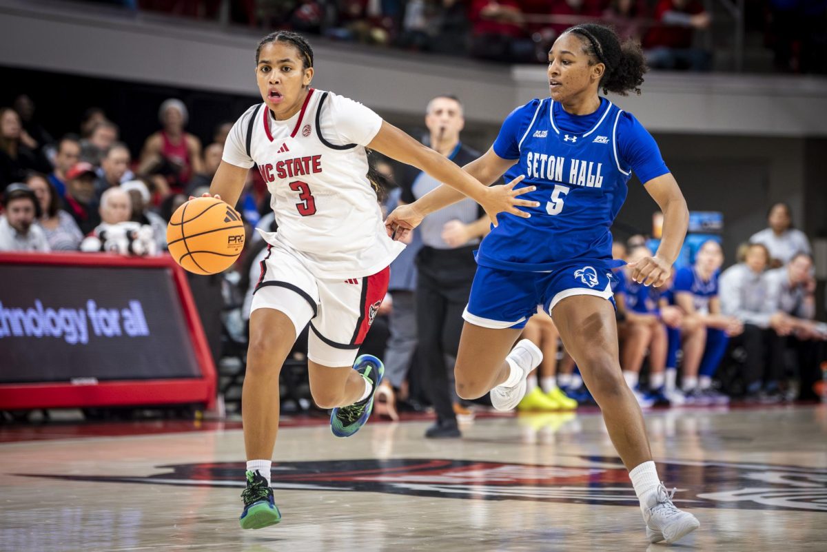 Sophomore guard Zamareya Jones fends off Seton Hall guard Savannah Catalon while driving towards the basket during the game in Reynolds Coliseum on Sunday, Dec. 7, 2025. Jones led the team with 12 points. The Wolfpack defeated the Pirates 61-53.
