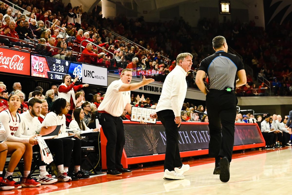 Head coach Wes Moore talks to a referee during the game against Seton Hall in Reynolds Coliseum on Sunday, Dec. 7, 2025. The Wolfpack defeated the Pirates 61-53.
