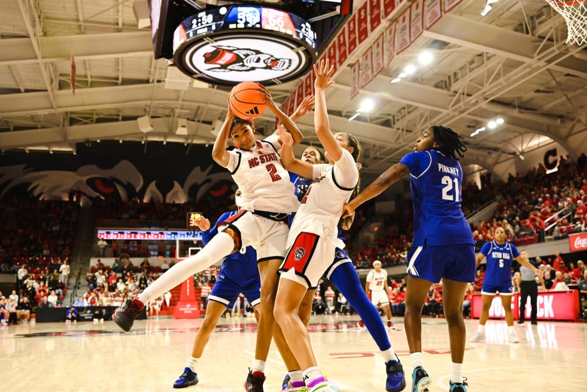 Junior guard Qadence Samuels falls into junior forward Khamil Pierre while trying to control the ball. Samuels scored five points and made four rebounds. The Wolfpack defeated the Pirates 61-53.