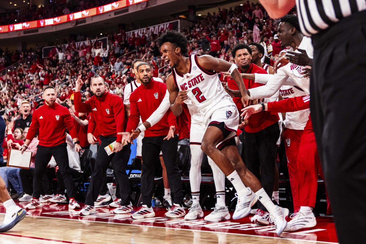 Sophomore guard Paul McNeil gets pushed up by his teammates after falling and making a three-point shot during the game against Virginia at Lenovo Center on Saturday, Jan. 3, 2026. McNeil scored 13 points. The Cavaliers beat the Wolfpack 76-61.