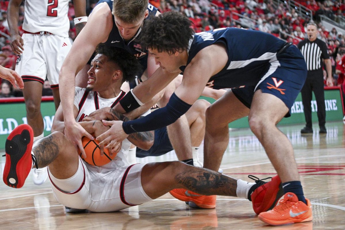 Senior forward Darrion Williams fights for a loose ball on the floor during the game against Virginia at the Lenovo Center on Saturday, Jan. 3, 2026. Williams scored a total of seven points. The Cavaliers beat the Wolfpack 76-61.