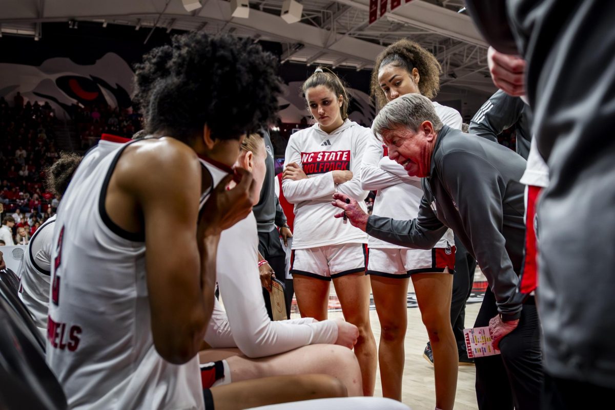 NC State head coach Wes Moore speaks to his team during a timeout of the game against Louisville in Reynolds Coliseum on Sunday, Jan. 18, 2026. The Cardinals defeated the Wolfpack 88-80 in overtime.