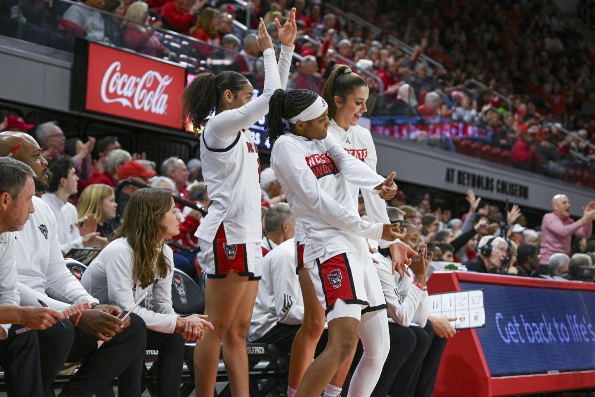 Freshman guard Destiny Lunan, sophomore guard Devyn Quigley, and freshman guard Adelaide Jernigan cheer after a three-pointer during the game against SMU in Reynolds Coliseum on Sunday, Jan. 11, 2026. The Wolfpack defeated the Mustangs 90-54.