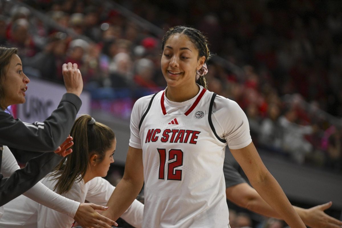 Junior forward Khamil Pierre smiles with the bench during the game against Stanford at Reynolds Coliseum on Thursday, Jan. 1, 2026. Pierre scored a total of 10 points. The Wolfpack defeated the Cardinals 74-46.