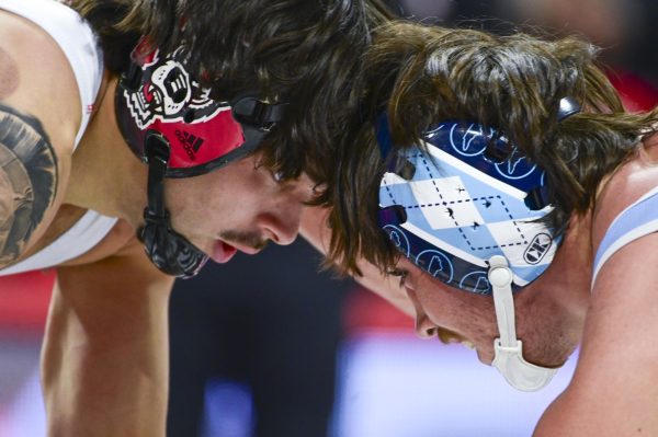 Redshirt freshman Luca Felix butt heads with hois opponent during the wrestling match against UNC-Chapel Hill in Reynolds Coliseum on Friday, Jan. 23, 2026. The Wolfpack beat the Tar Heels 24-10.