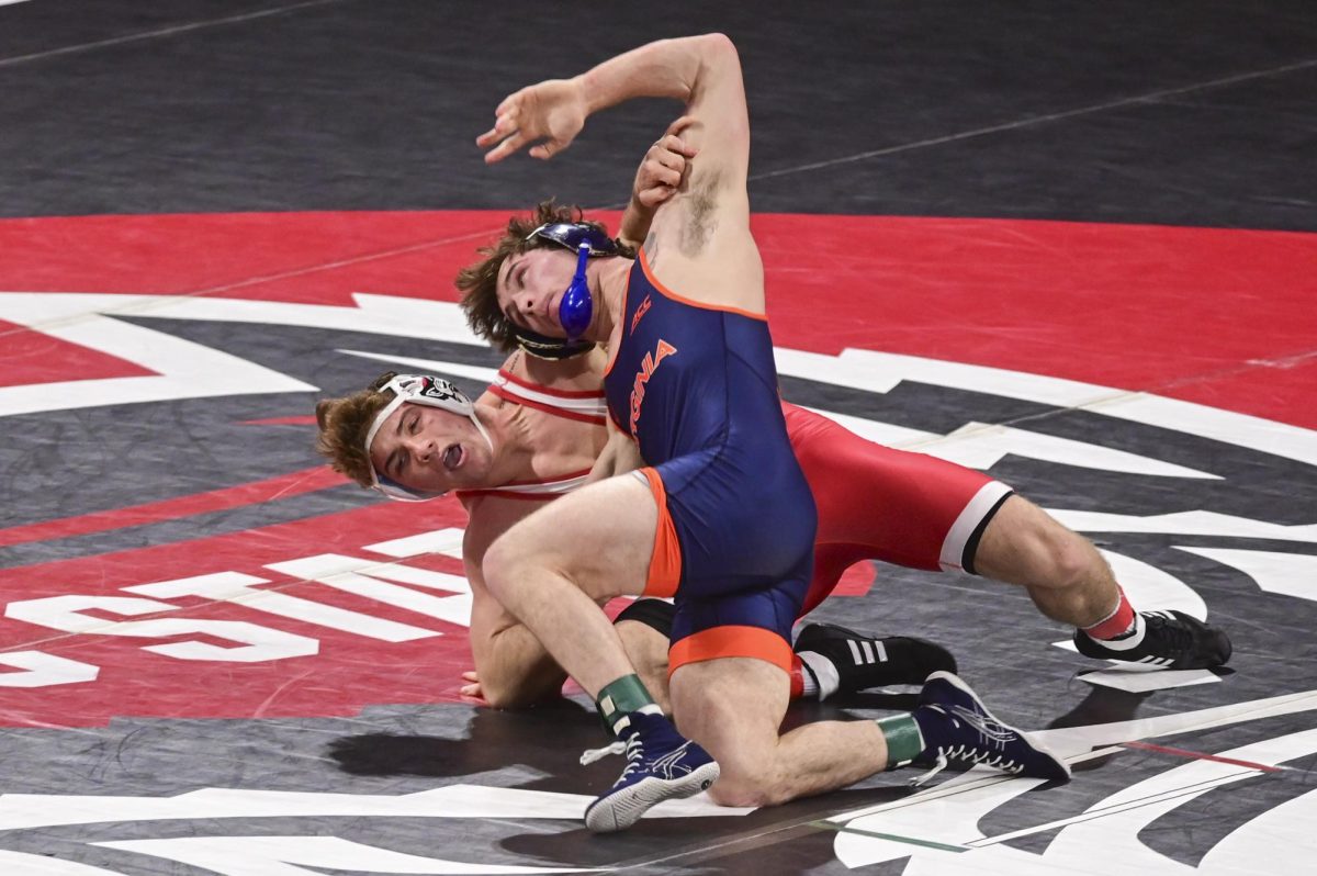 Freshman Will Denny holds back his opponent during the wrestling match against Virginia in Reynolds Coliseum on Friday, Jan. 9, 2026. Denny  won the 165 bout by major decision 9-1. NC State beat Virginia 19-17.
