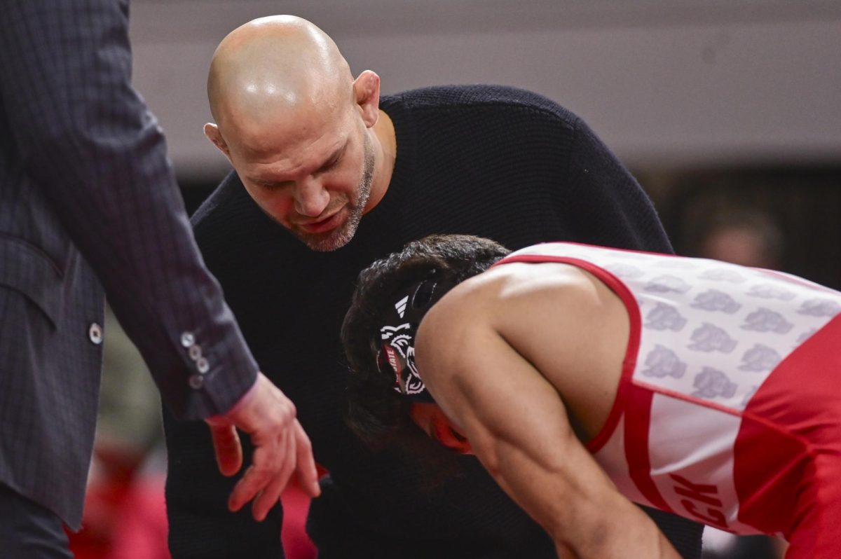 NC State wrestling associate coach Zack Esposito talks to redshirt Matty Singleton during the wrestling match against Virginia in Reynolds Coliseum on Friday, Jan. 9, 2026. NC State beat Virginia 19-17.