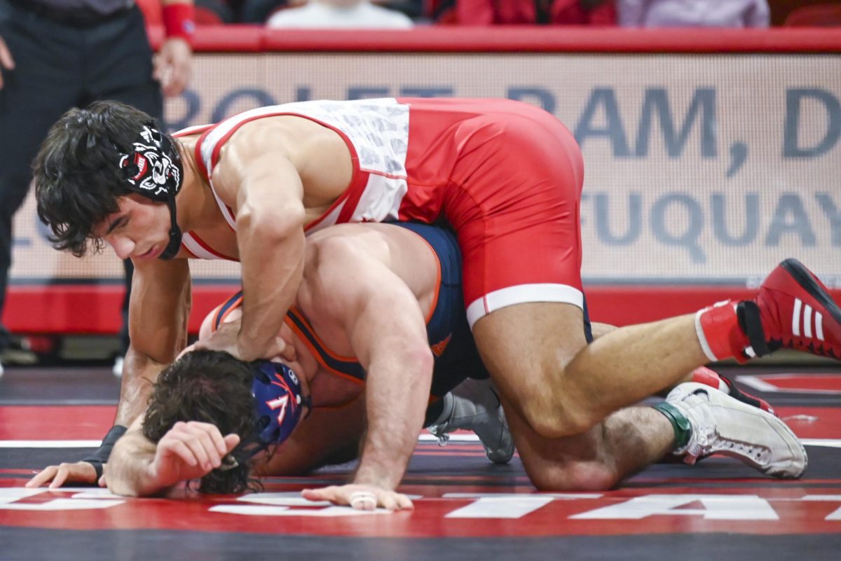 Redshirt junior Matty Singleton holds down his opponent's head during the wrestling match against Virginia in Reynolds Coliseum on Friday, Jan. 9, 2026. Singleton won the 174 bout 7-1.  NC State beat Virginia 19-17.