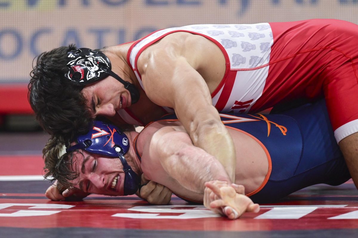 Redshirt junior Matty Singleton restrains his opponent during the wrestling match against Virginia in Reynolds Coliseum on Friday, Jan. 9, 2026. Singleton won the 174 bout 7-1.  NC State beat Virginia 19-17.
