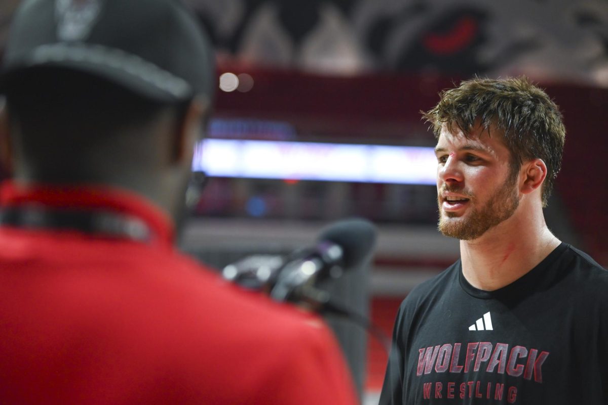 Sixth-year wrestler Isaac Trumble gets interviewed after the wrestling match against Virginia in Reynolds Coliseum on Friday, Jan. 9, 2026. Trumble won the 285 bout by fall, securing enough points for NC State to beat Virignia in the process. NC State beat Virginia 19-17.