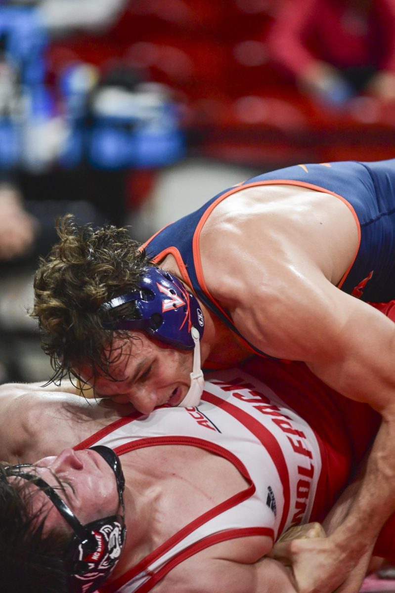Freshman wrestler Brogan Tucker gets brought to the ground by his opponent during the wrestling match against Virginia in Reynolds Coliseum on Friday, Jan. 9, 2026. NC State beat Virginia 19-17.
