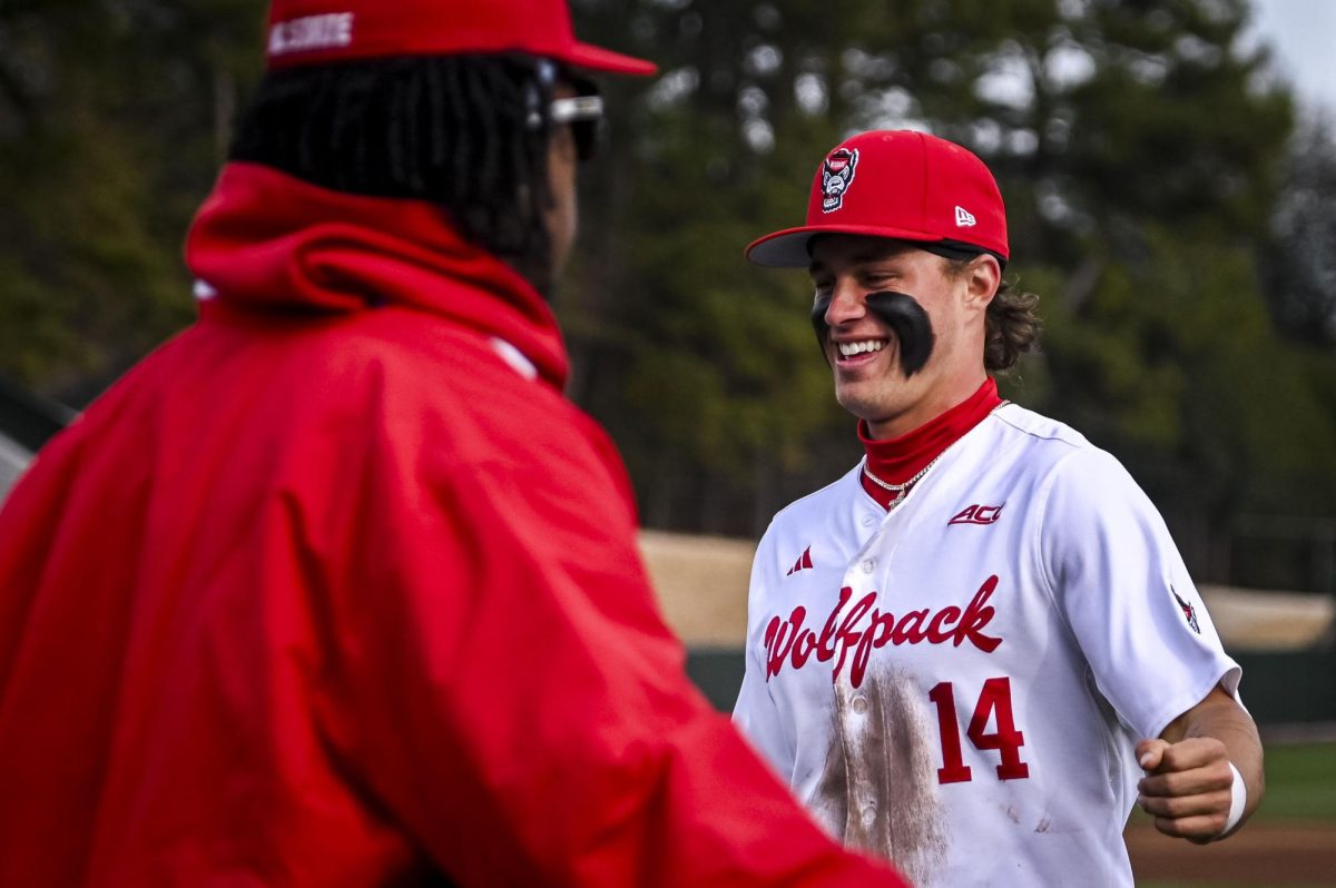 Junior outfielder Andrew Wiggins and Sophomore outfielder Ty Head fist bump between innings during the game against Richmond at Doak Field in Dail Park on Tuesday, Feb. 24, 2026. The Wolfpack defeated the Spiders 27-0.