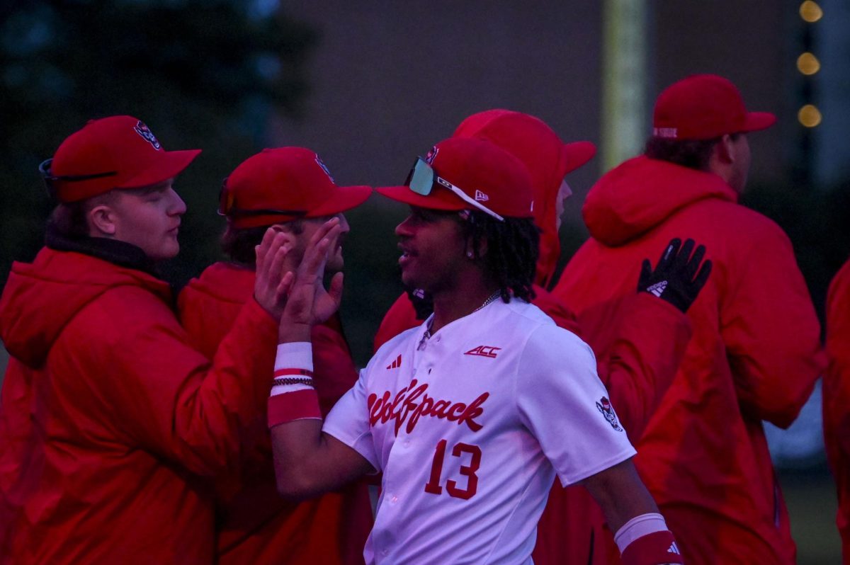 Junior outfielder Andrew Wiggins high fives teammates after the game against Richmond at Doak Field in Dail Park on Tuesday, Feb. 24, 2026. The Wolfpack defeated the Spiders 27-0.