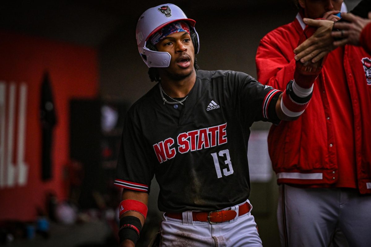 NC State junior outfielder Andrew Wiggins high-fives his teammates after a home run during the game against Sacred Heart in Doak Field at Dail Park on Friday, Feb. 27, 2026. The Wolfpack defeated the Pioneers 17-4.