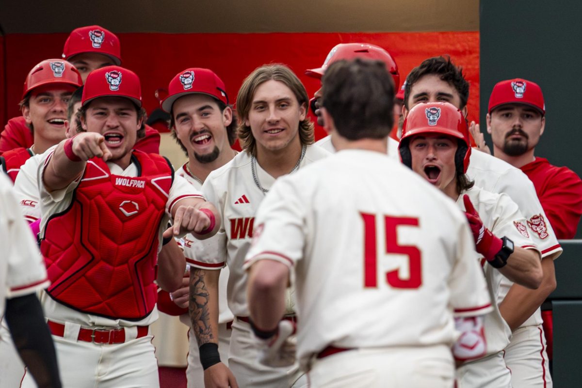 Players wait to celebrate with redshirt-junior catcher Drew Lanphere after he crosses home plate during the game against Winthrop in Doak Field at Dail Park on Wednesday, Feb. 18, 2026. Lanphere led the team with three RBI's. The Wolfpack defeated the Eagles 7-3.