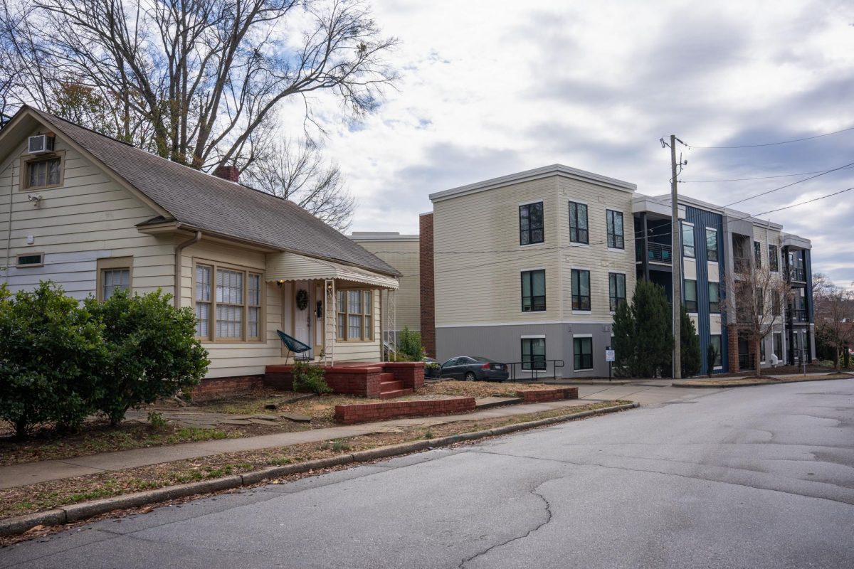 A house sits next to an apartment complex developed in 2019 on Chamberlain Street.