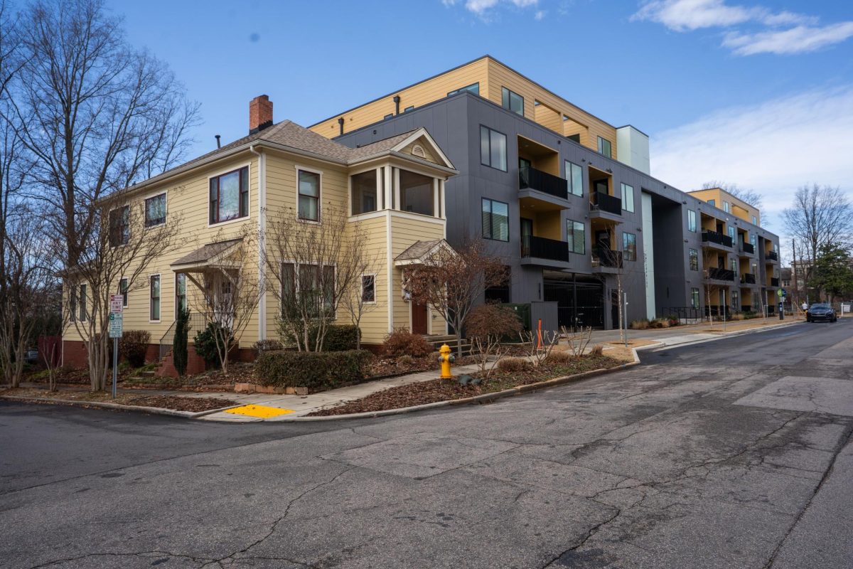 A house sits on the corner of Enterprise and Hope Street next to an apartment complex developed in 2024.