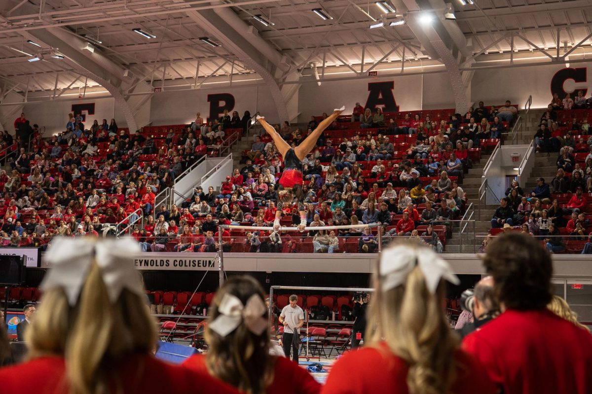 Junior Elle Hadrick goes into a handstand on the bar during the meet against UNC at Reynolds Coliseum on Sunday, Feb. 8, 2025. Hadrick scored a 9.875 on her bar routine. NC State beat UNC 197.125-196.525.