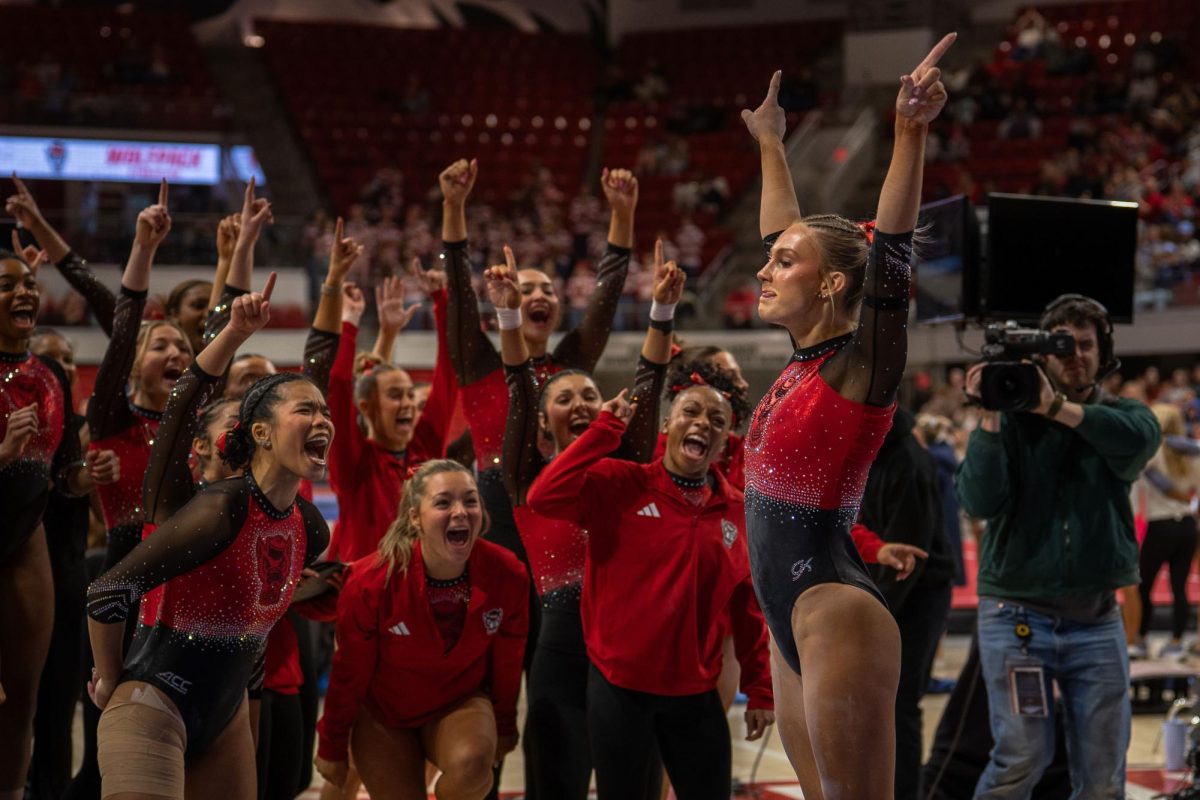 Junior Katie Harper celebrates with her team after completing her beam routine during the meet against UNC at Reynolds Coliseum on Sunday, Feb. 8, 2025. Harper scored a 9.850 on her beam routine. NC State beat UNC 197.125-196.525.