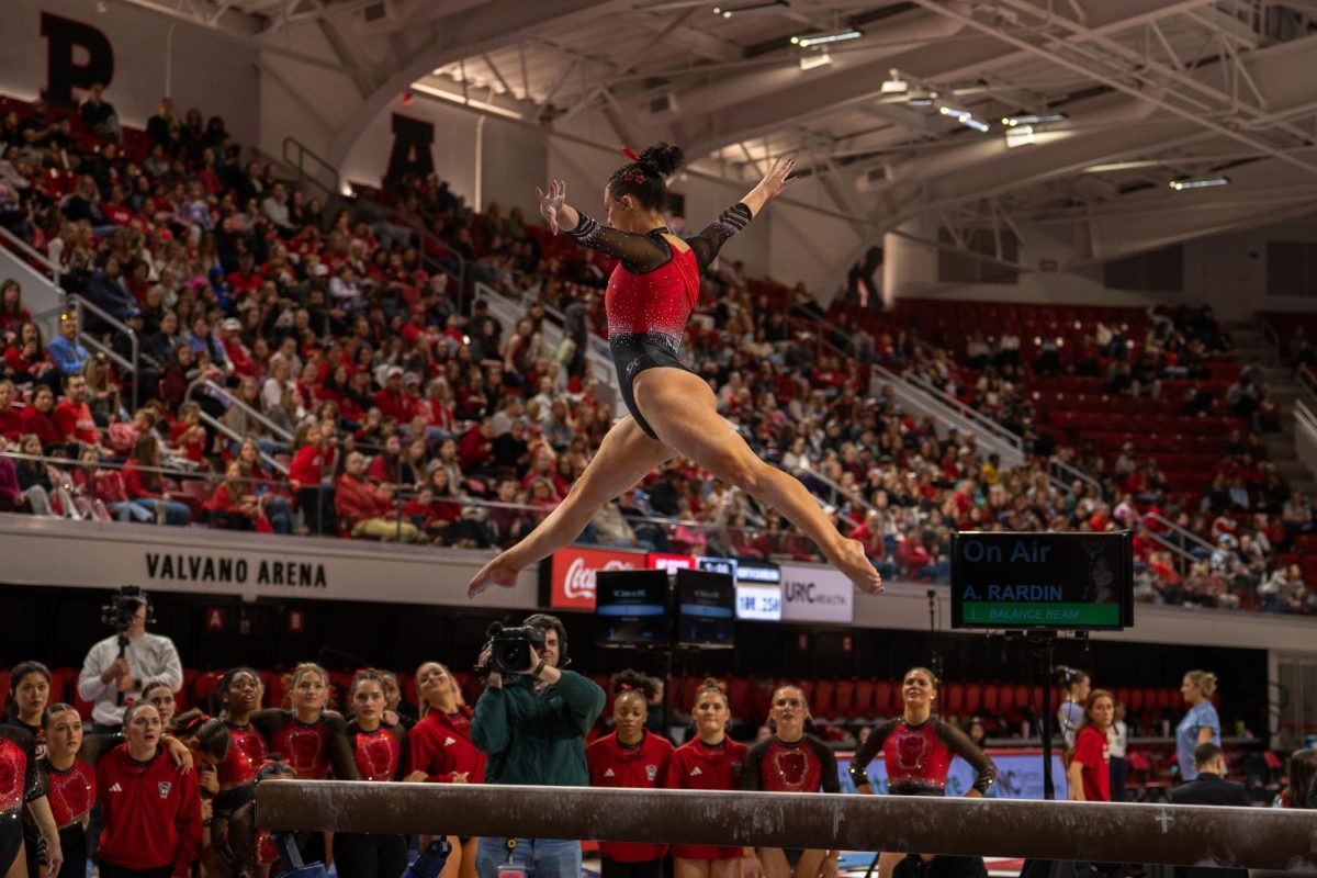 Freshman Autumn Rardin jumps up over the beam during the meet against UNC at Reynolds Coliseum on Sunday, Feb. 8, 2025. Rardin scored a 9.900 on her floor routine. NC State beat UNC 197.125-196.525.