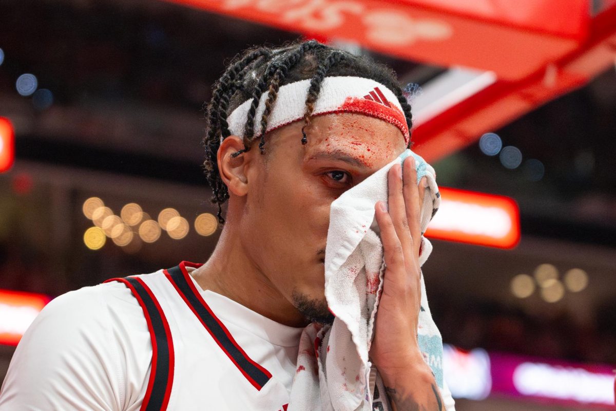 Senior forward Darrion Williams covers his face during the game against North Carolina at the Lenovo Center on Tuesday, Feb. 17, 2026. Williams finished with 13 points and returned to the game after getting stitched up following a fall in the first half. The Wolfpack defeated the Tar Heels 82–58.