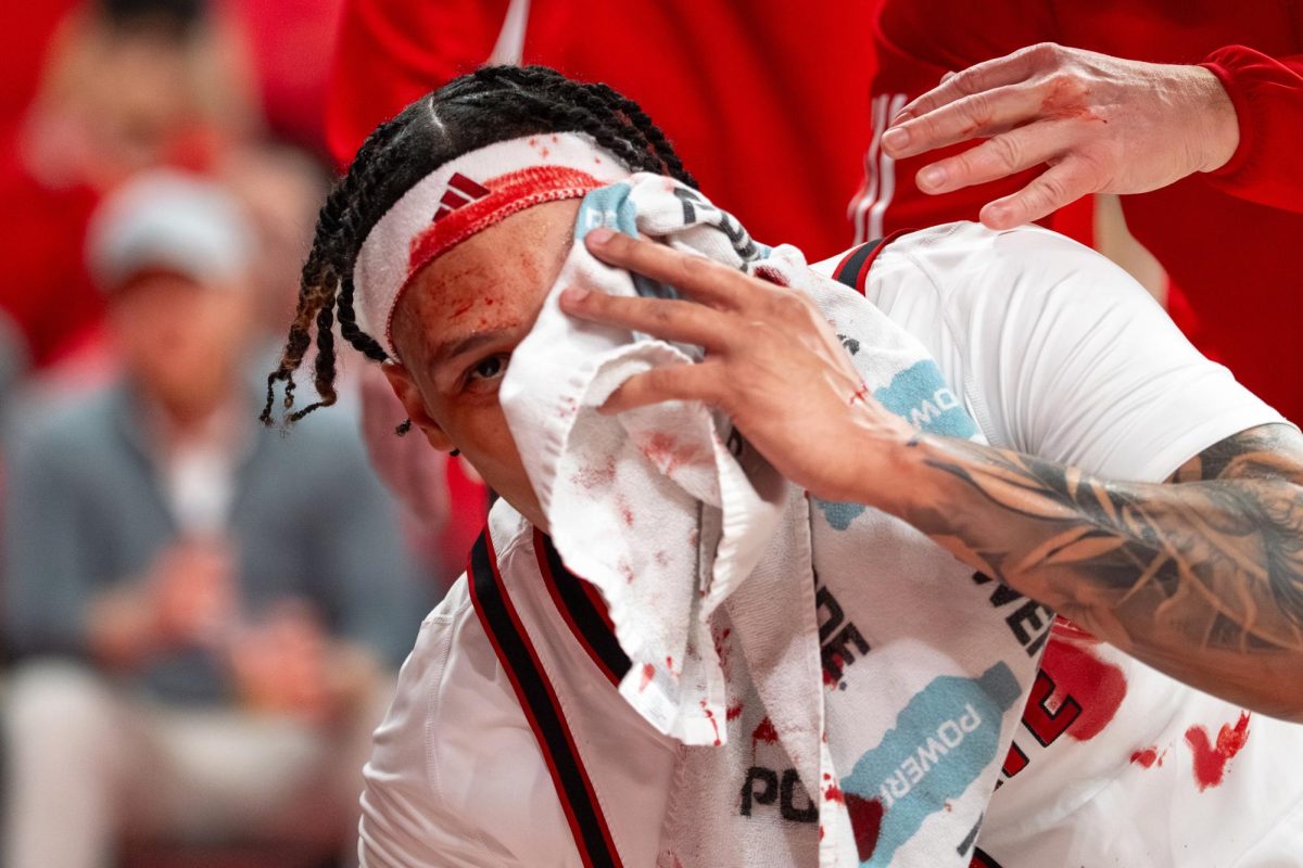 Senior forward Darrion Williams covers his face during the game against North Carolina at the Lenovo Center on Tuesday, Feb. 17, 2026. Williams finished with 13 points and returned to the game after getting stitched up following a fall in the first half. The Wolfpack defeated the Tar Heels 82–58.