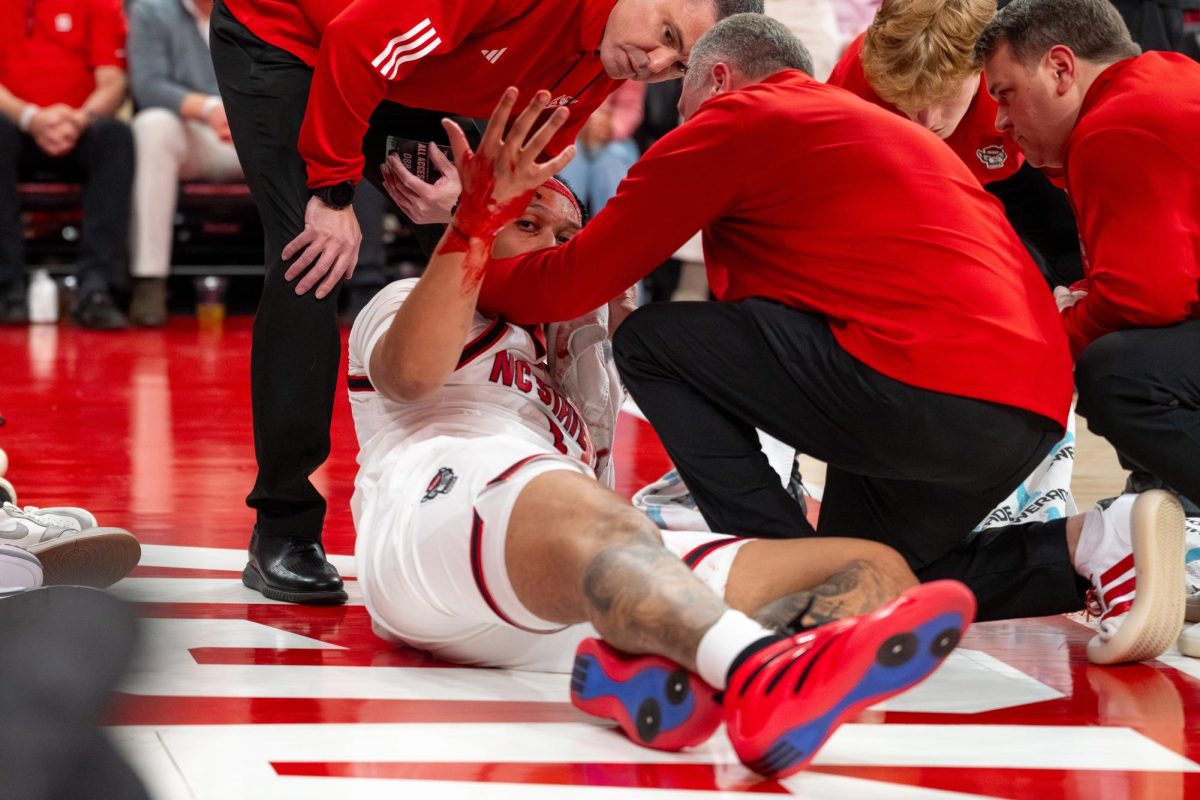 Senior forward Darrion Williams raises his hand after falling during the game against North Carolina at the Lenovo Center on Tuesday, Feb. 17, 2026. Williams finished with 13 points and returned to the game after getting stitched up following a fall in the first half. The Wolfpack defeated the Tar Heels 82–58.